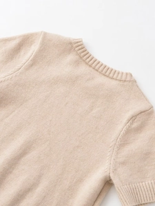Detail shot of the beige knit sweater neckline showing the premium ribbed texture