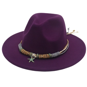 Dettaglio del fedora in lana viola con ciondolo a stella e fascia intrecciata tricolore