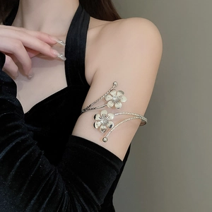 Close-up of silver multilayer floral arm cuff featuring crystal accents on smooth metal