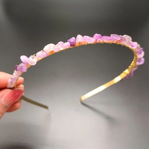 Detail of purple and pink crystal stones hand-wrapped on a golden bridal headband