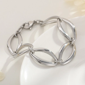 Macro shot of silver oversized oval link bracelet with mirror finish on white plate