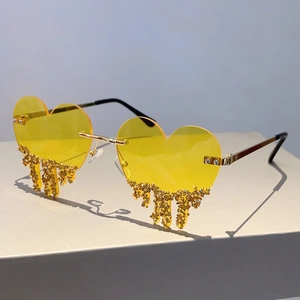 Detailed view of yellow heart-shaped rimless sunglasses with gold glitter teardrop accents