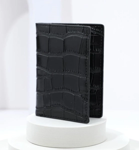 Detailed view of matte black crocodile pattern texture and stitching on card holder