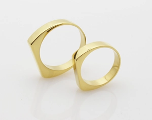 Detail of minimalist gold plated titanium steel rings with geometric flat square top face