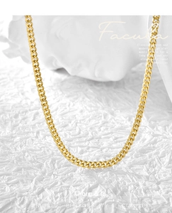 Detailed close-up of golden Cuban link necklace with polished metal rings