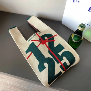 Détail du sac de Noël en maille crème avec texte Merry Christmas et motifs festifs rouges
