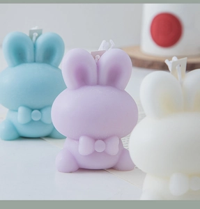 Detailed view of cute rabbit shaped scented candles in blue, purple and white wax