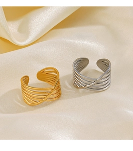 Detailed view of layered crisscross open rings in gold and silver on silk fabric