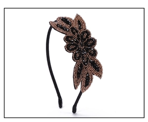Detail of handcrafted beaded black and bronze flower ornament on retro queen headband