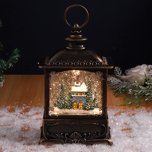 Detail of vintage bronze Christmas lantern with swirling snow, house and warm LED light