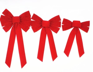 Detailed view of red velvet Christmas bows in large, medium, and small sizes with long ribbons