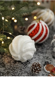 Detail einer weißen Weihnachtskugel mit Glitzerspirale und festlicher Dekoration