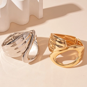 Geometric asymmetric hollow metal bangle in gold and silver with lava flow design style