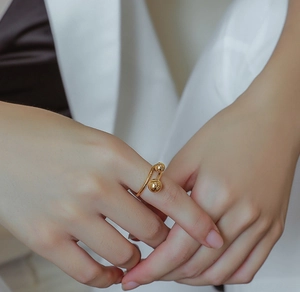 Minimalist gold double ball open ring shown on finger with sleek titanium steel finish