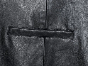 Detailed close-up of stitching and black grain faux leather texture on long casual shorts