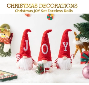 Detailed view of three festive Christmas gnomes with JOY letters on knitted hats