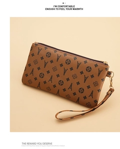Detail of vintage brown wristlet bag with Eiffel Tower and floral pattern print