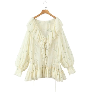 Dettaglio dei ricami floreali e delle balze su un abito in chiffon con scollo a V