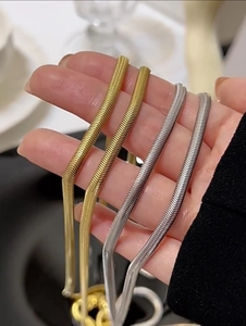 Detailed view of flexible gold and silver snake bone necklaces with high polish finish