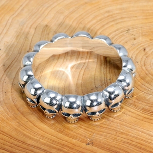 Vue détaillée d'une bague tête de mort punk vintage sur bois montrant la texture argentée