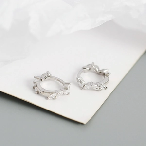 Detailed macro view of silver hoop earrings featuring sparkling marquise-cut zircon stones