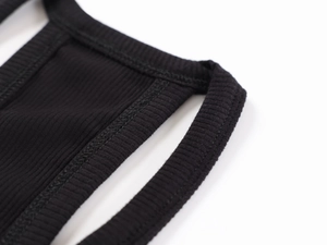 Macro detail of black ribbed knit fabric showing fine stitching and premium texture