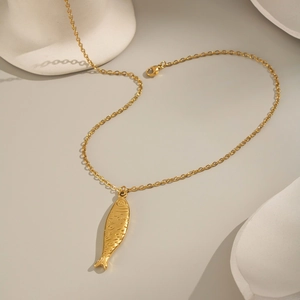 Détail du pendentif poisson doré avec écailles texturées sur une fine chaîne à maillons O