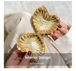 Detailed view of internal mirror finish and magnetic closure of golden shell bag