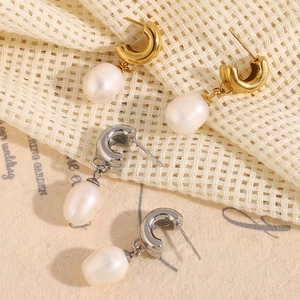 Close-up of C-shaped baroque pearl earrings in gold and silver stainless steel finishes