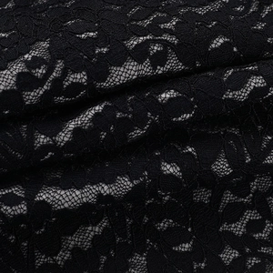Macro detail of black floral lace fabric with intricate crochet patterns and fine mesh texture