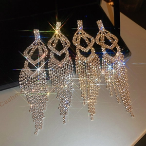 Macro shot of silver tassel earrings featuring geometric rhinestones and starburst effect