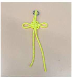 Detail of yellow hand-woven knot pendant with silver metal ring on pink background