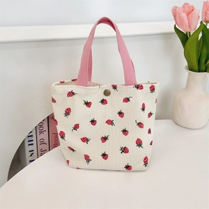 Détail du sac cabas en velours côtelé fraise avec anse rose et bouton pression métal