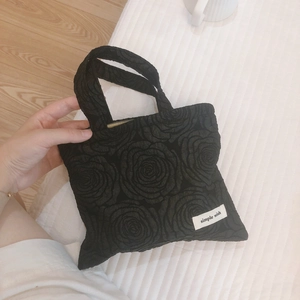 Mini handbag with 3D rose texture and simple wish label on white striped background