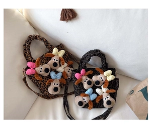 Detail view of two leopard print plush crossbody bags with cartoon dog charms for girls