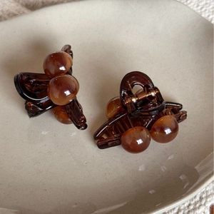 Paire de petites pinces à cheveux en résine ambrée sur une assiette en céramique