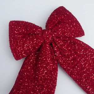 Close-up of a festive red sequined bow ornament with sparkling texture for holiday decor
