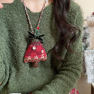 Detail of a handmade knitted Christmas tree pendant with buttons and a velvet bow