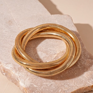 Macro shot of three-layered golden snake chain texture on minimalist metal bracelet