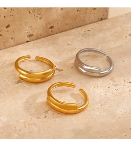 Close-up of geometric minimalist open rings in gold and silver on stone