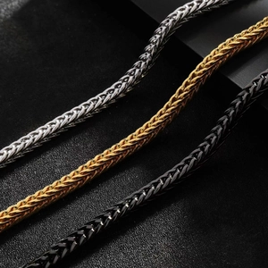 Detailed view of woven titanium steel bracelets in silver, gold, and black finishes