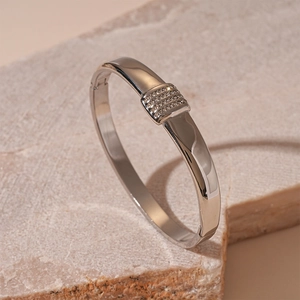 Detail of silver polished geometric cuff bracelet featuring four rows of inlaid zircons