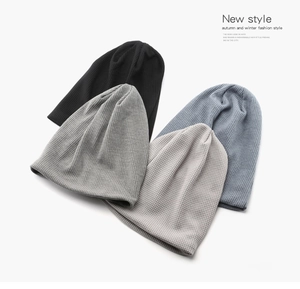 Detailed view of waffle knit beanies in black, gray, and beige showing soft texture