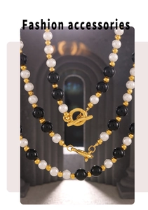 Detail of beaded necklace with black onyx, white pearls and gold OT toggle clasp