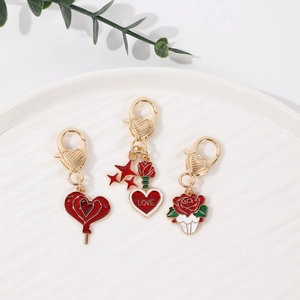 Detail view of pink heart and rose lobster clasp charms on white ceramic tray