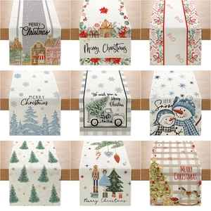 Nine various Christmas themed table runners with festive prints on rustic wooden background