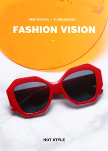 Detail of red oversized geometric sunglasses with wide frames on marble background