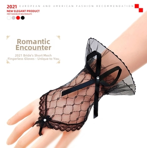 Detail of black lace fingerless gloves featuring mesh ribbon bow and rhinestone accent