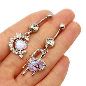 Detailed view of heart-shaped belly rings with rhinestones and crystals on a palm