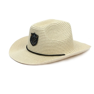 Macro detail of cow skull metal emblem on beige woven straw western cowboy hat